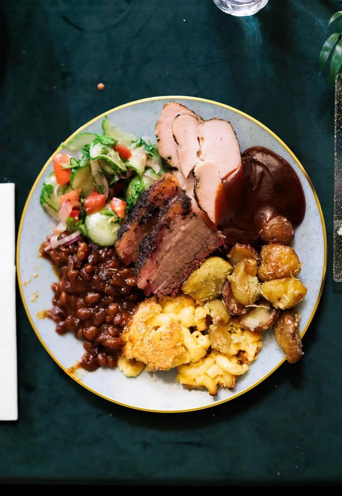 Overhead view of a plate filled with barbecue, salad, and sides.